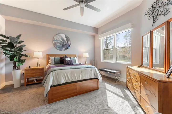 Carpeted bedroom with ceiling fan and baseboards