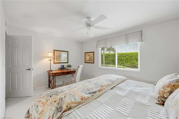 Bedroom with ceiling fan and light carpet