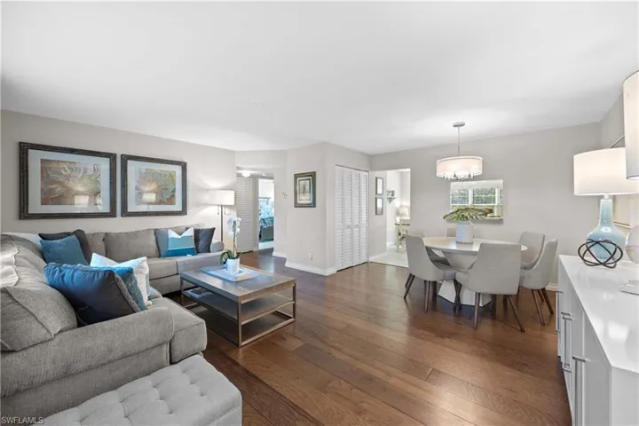 Living room with dark wood-type flooring and a chandelier