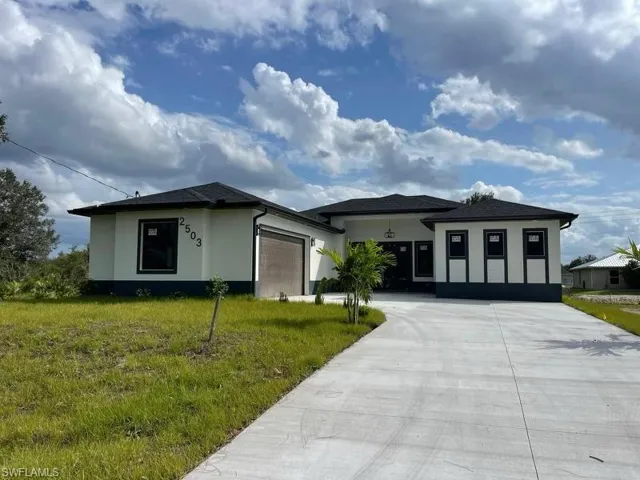 View of front of house with a front lawn and a garage