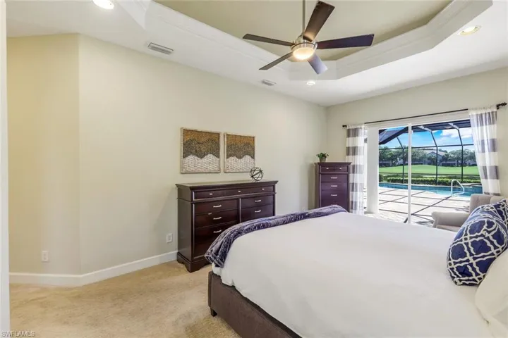Primary bedroom with lanai access and lake/golf view