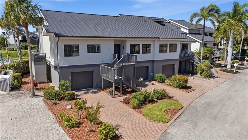 View of front of property featuring a metal roof, decorative driveway, and an attached garage