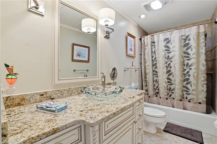Full bath with vanity, shower / tub combo with curtain, and ornamental molding