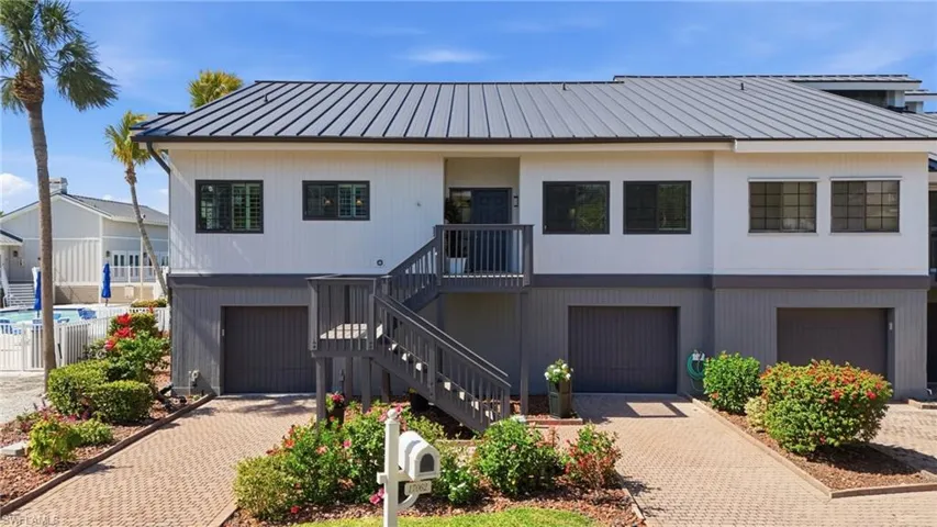 View of front of house featuring a garage, decorative driveway, and a standing seam roof