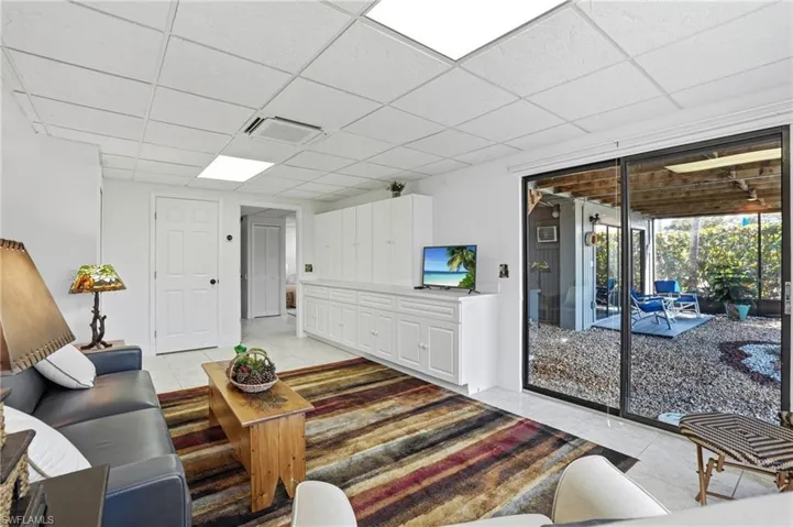 Living room with a paneled ceiling and light tile patterned floors