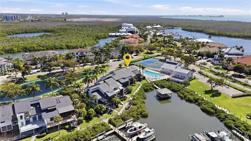 Aerial view of residential area with a large body of water and a heavily wooded area