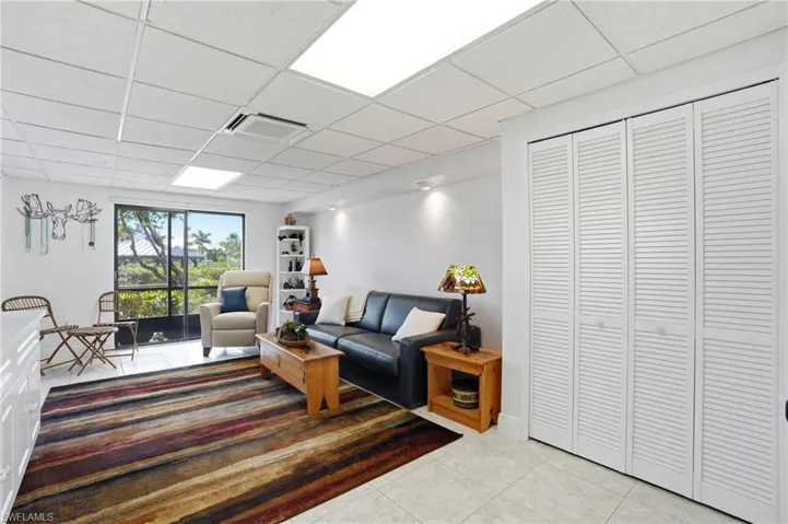 Living area featuring a drop ceiling and light tile patterned floors
