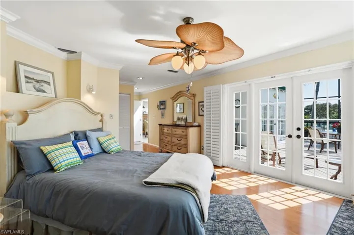 Bedroom featuring french doors, access to exterior, ornamental molding, light wood-style floors, and ceiling fan