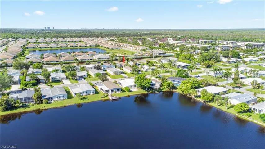 Aerial view of property and surrounding area with nearby suburban area and a large body of water