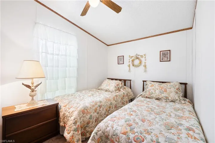 Bedroom featuring lofted ceiling, ornamental molding, and a ceiling fan
