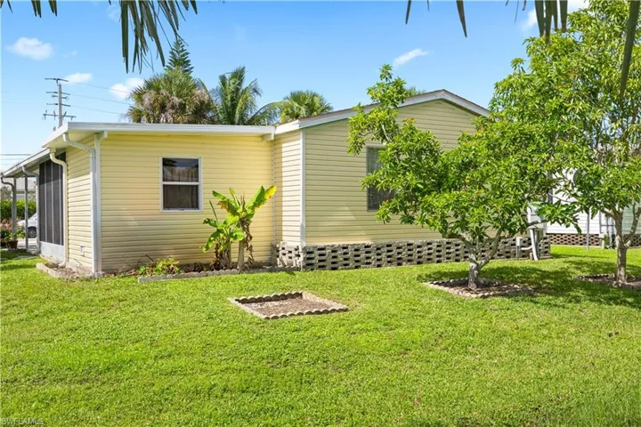 View of side of property with a yard and a sunroom