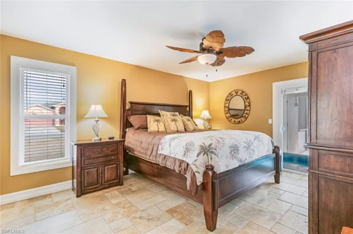 Bedroom with stone tile flooring and ceiling fan - Virtually Edited Image
