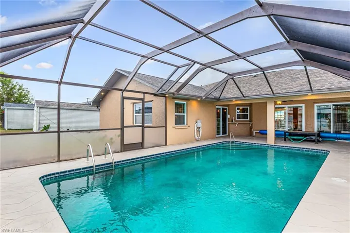 Outdoor pool with a lanai, a sunroom, and a patio - Virtually Edited Image