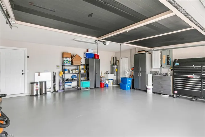 Garage with electric water heater and electric panel - Virtually Edited Image