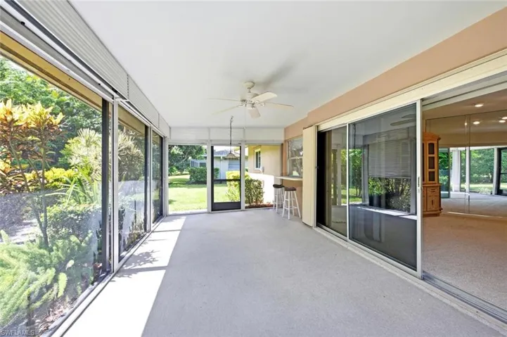 Screened patio area featuring a ceiling fan, light-colored flooring, and full-height screens