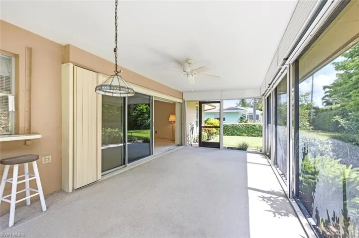 Screened lanai featuring concrete flooring and a ceiling fan
