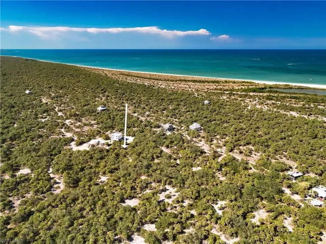 Birds eye view of property with a view of the beach and a water view
