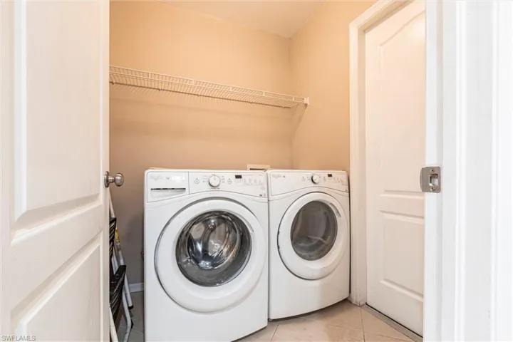 Laundry area with light tile floors, separate washer and dryer, and laundry area