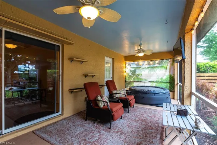 Sunroom with a textured wall and ceiling fan