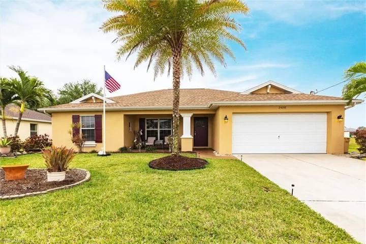 Ranch-style home with a garage, a front yard, driveway, and stucco siding