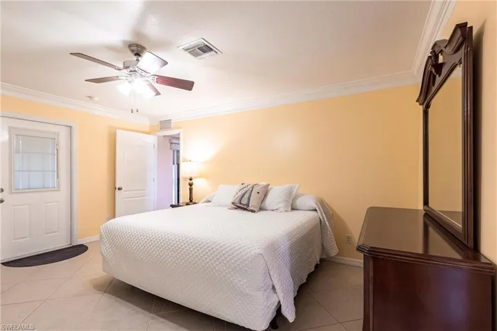 Bedroom with crown molding, light tile flooring
