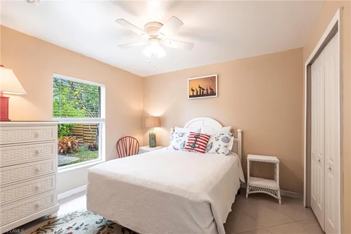 Bedroom with tile floors, a closet, baseboards, and ceiling fan