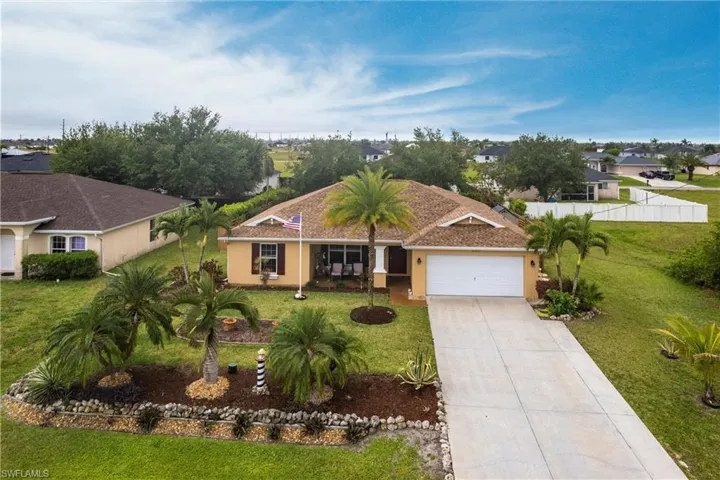 View of front of home with stucco siding, concrete driveway, a garage, and a front lawn
