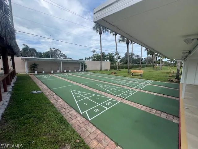 View of home's community with a yard and shuffleboard