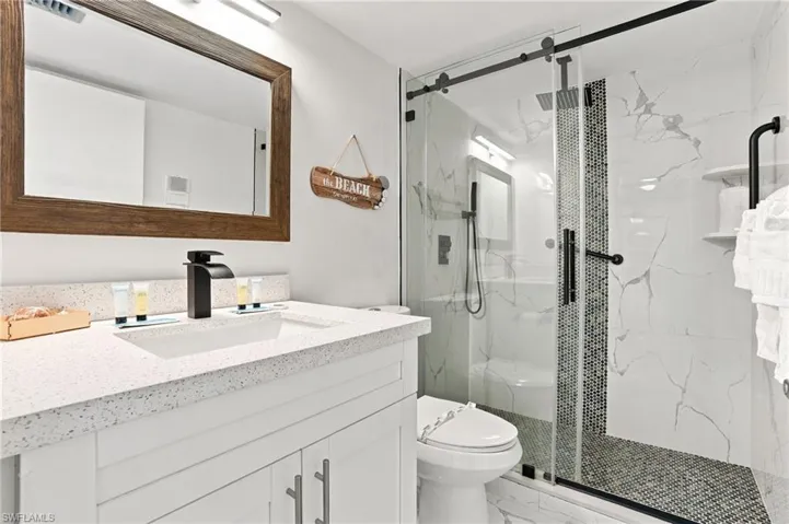 Vanity with a light-colored countertop, recessed sink, and matte black faucet - Virtually Edited Image