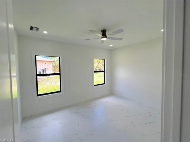 Primary bedroom with plenty of natural light, ceiling fan, and recessed lighting