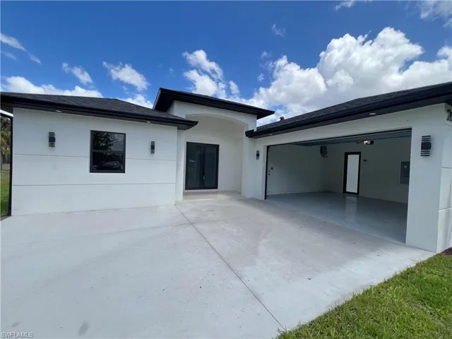 View of front facade featuring driveway and an attached garage