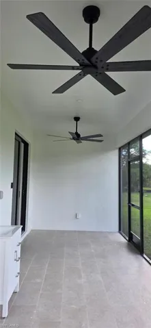 Screened lanai featuring large ceiling fan and sink