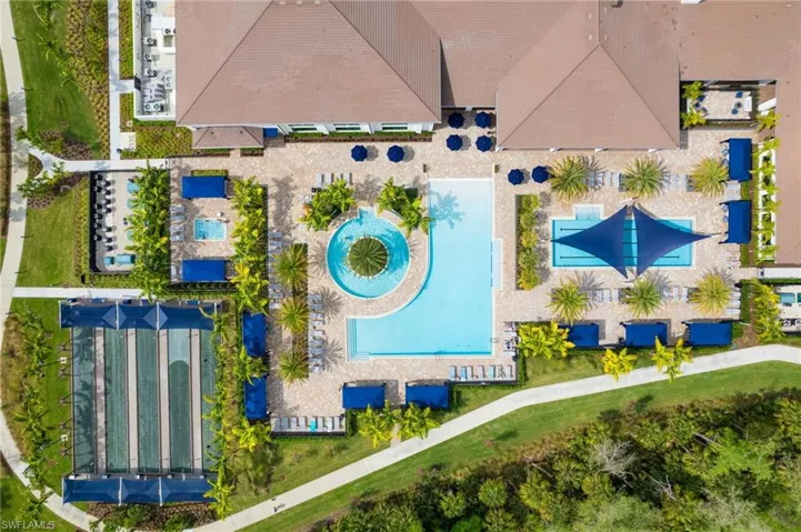 Resort-style amenities featuring multiple swimming pools, a circular water feature, shaded lounge areas, and bocce ball courts