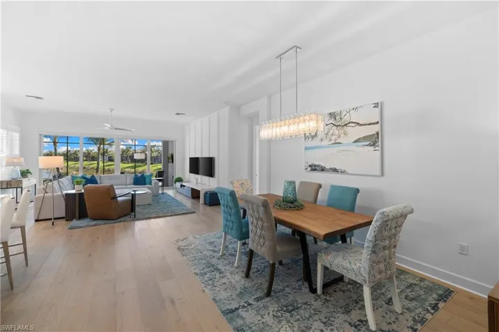 Open-concept living and dining area featuring light wood-finish flooring
