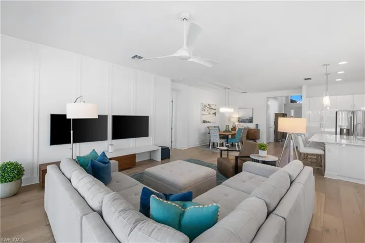 Expansive open concept interior featuring wood-finish flooring, a modern ceiling fan, and recessed lighting