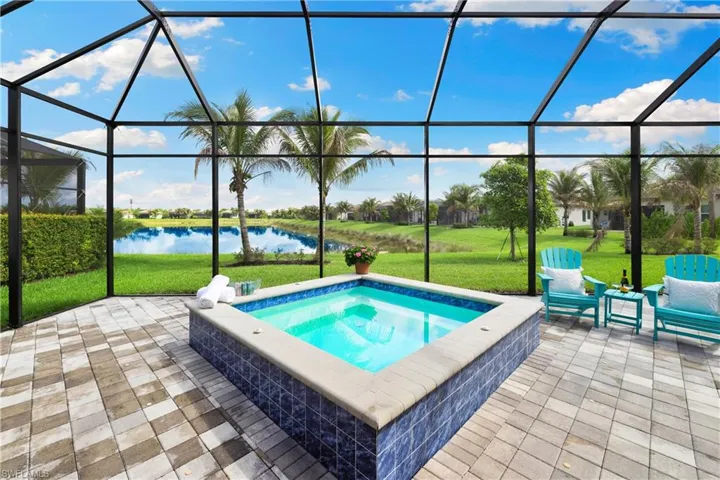Screened-in patio featuring a built-in spool with pavers and a lake view