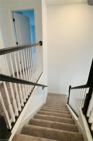 Stairs featuring baseboards and carpet