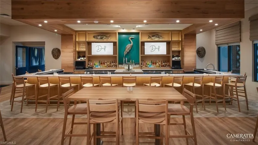 Indoor wet bar with recessed lighting and open shelves