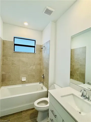 Bathroom featuring vanity,  shower combination, and wood tiled floors