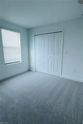 Unfurnished bedroom with carpet flooring and a closet