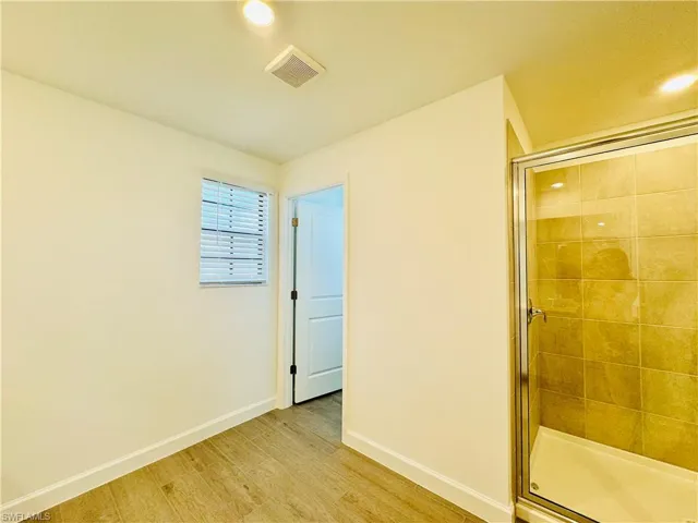 Full bathroom featuring light wood-style flooring and a stall shower