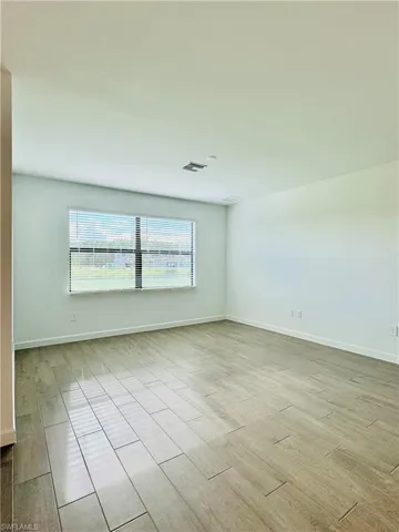 Empty room featuring wood tiled floors and baseboards
