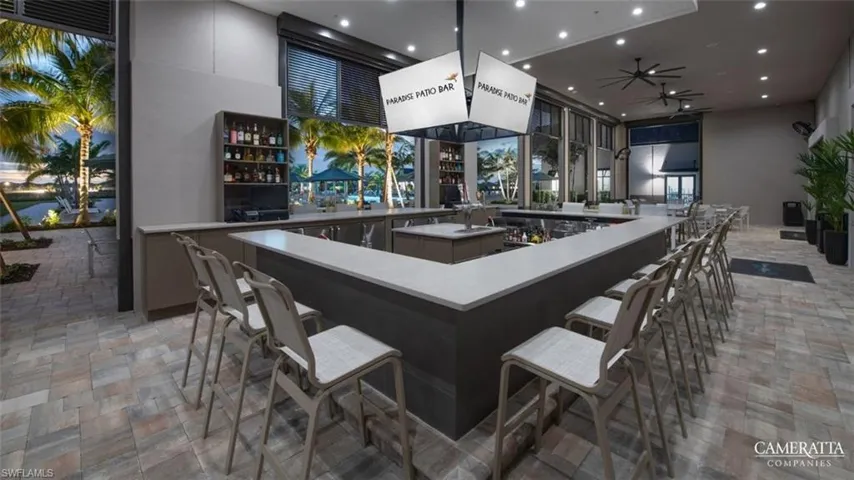 Indoor wet bar with a high ceiling, recessed lighting, a ceiling fan, and gray cabinets