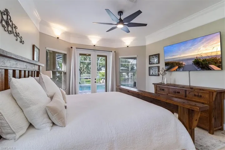 Bedroom with crown molding, access to outside, french doors, and ceiling fan
