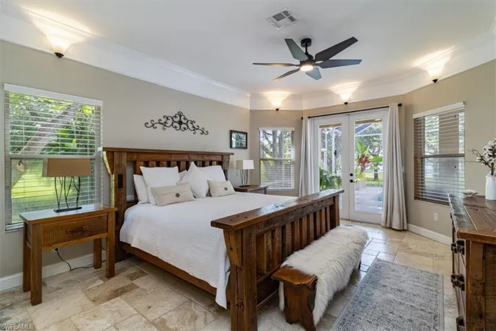 Bedroom featuring crown molding, french doors, light tile patterned floors, access to outside, and ceiling fan