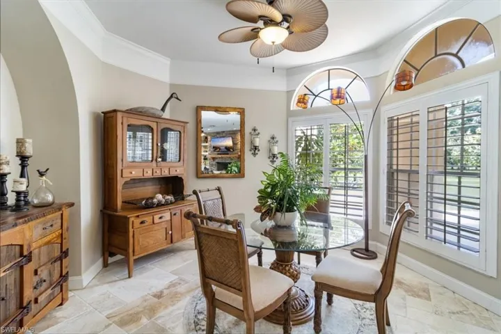 Dining room with ornamental molding, light tile patterned floors, and ceiling fan
