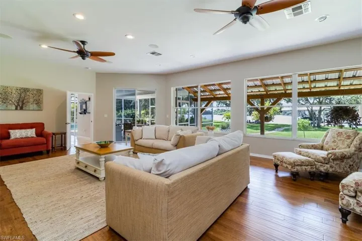 Living room with ceiling fan and hardwood / wood-style flooring