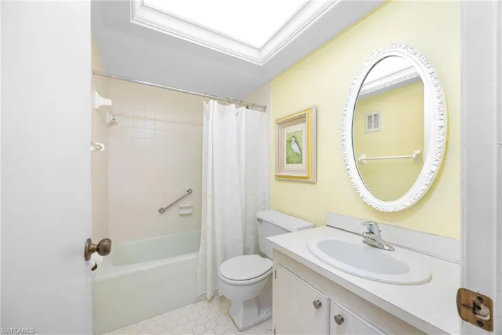 Bathroom with shower / bath combo, visible vents, vanity, and toilet