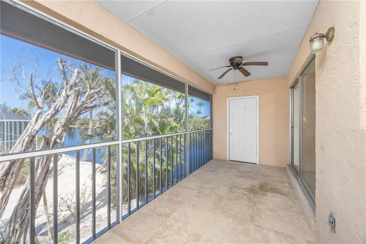 Balcony featuring a water view and ceiling fan
