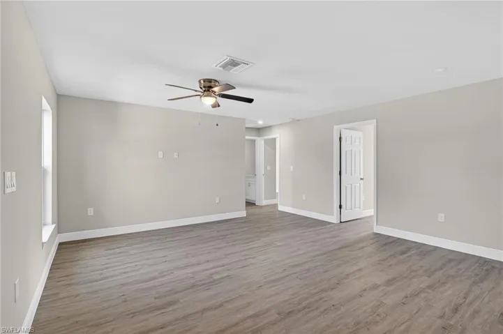 Empty room with a ceiling fan and light wood-style flooring